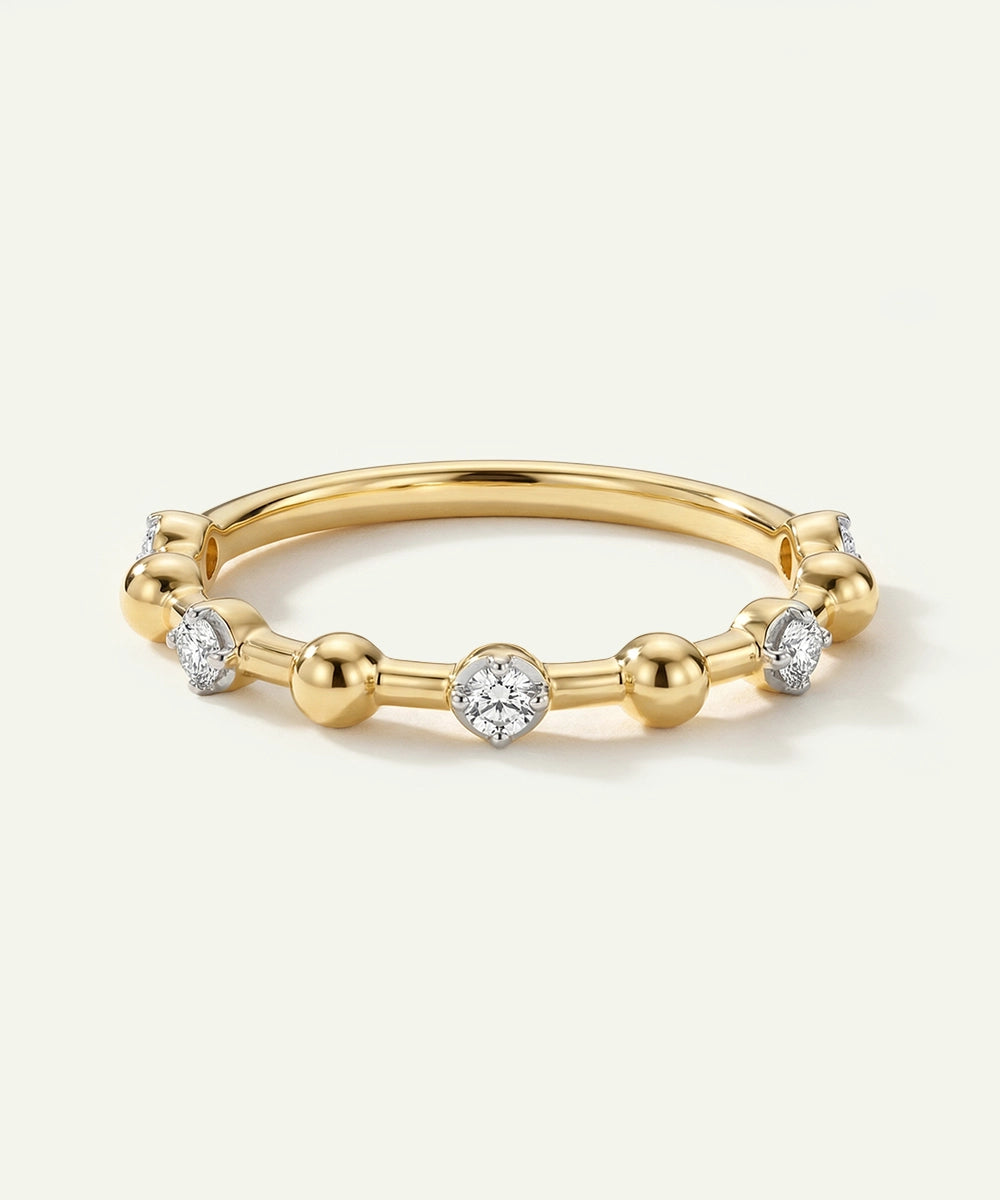Gold ring with small diamonds on a light beige background