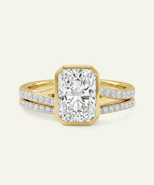 Gold ring with a large diamond and smaller diamonds on the band against a white background