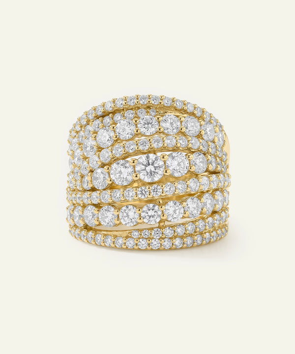 Gold ring with multiple diamond bands on a light beige background