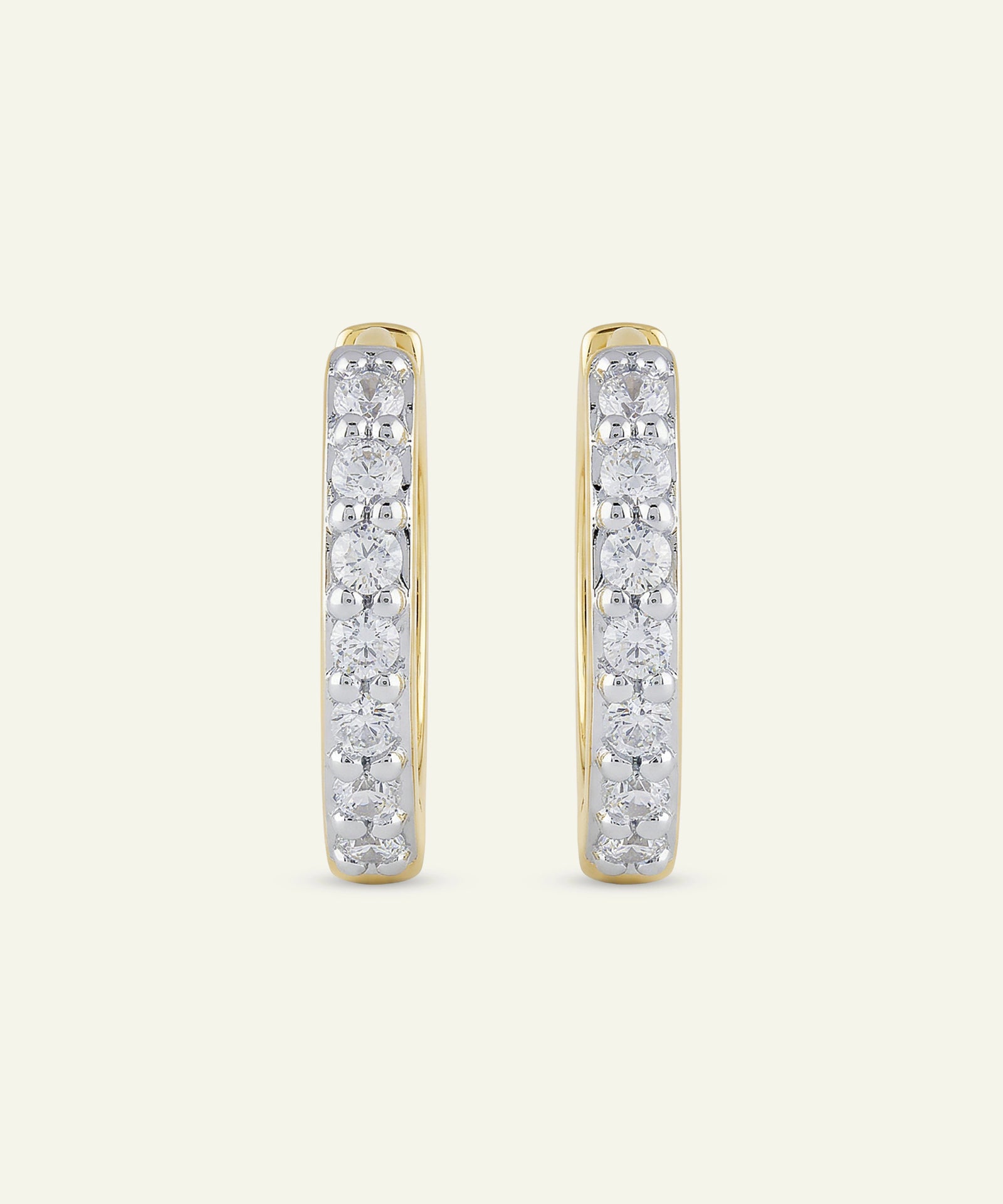 Pair of diamond hoop earrings on a light beige background