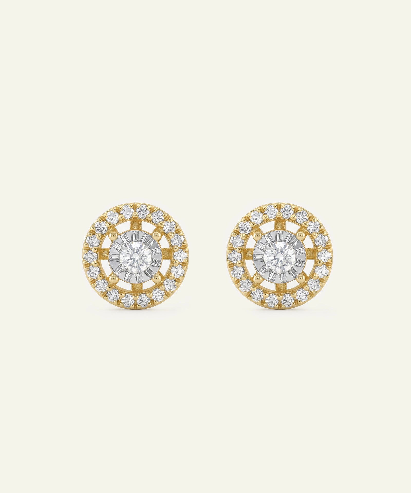 Pair of gold and diamond earrings on a light beige background