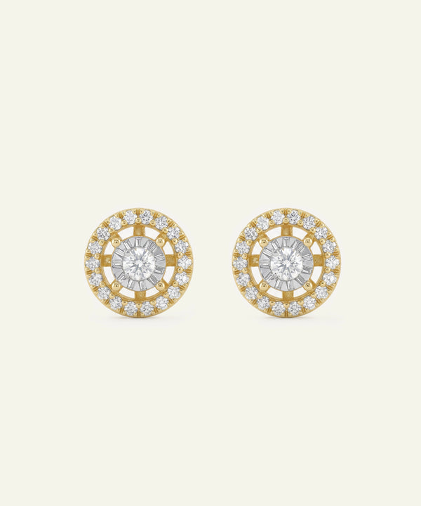 Pair of gold and diamond earrings on a light beige background