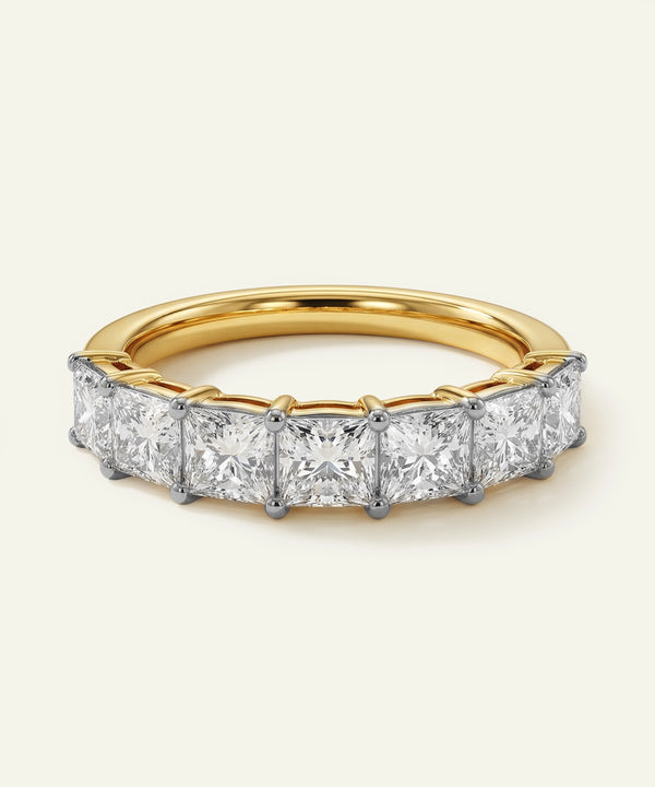 Gold ring with diamond stones on a light beige background