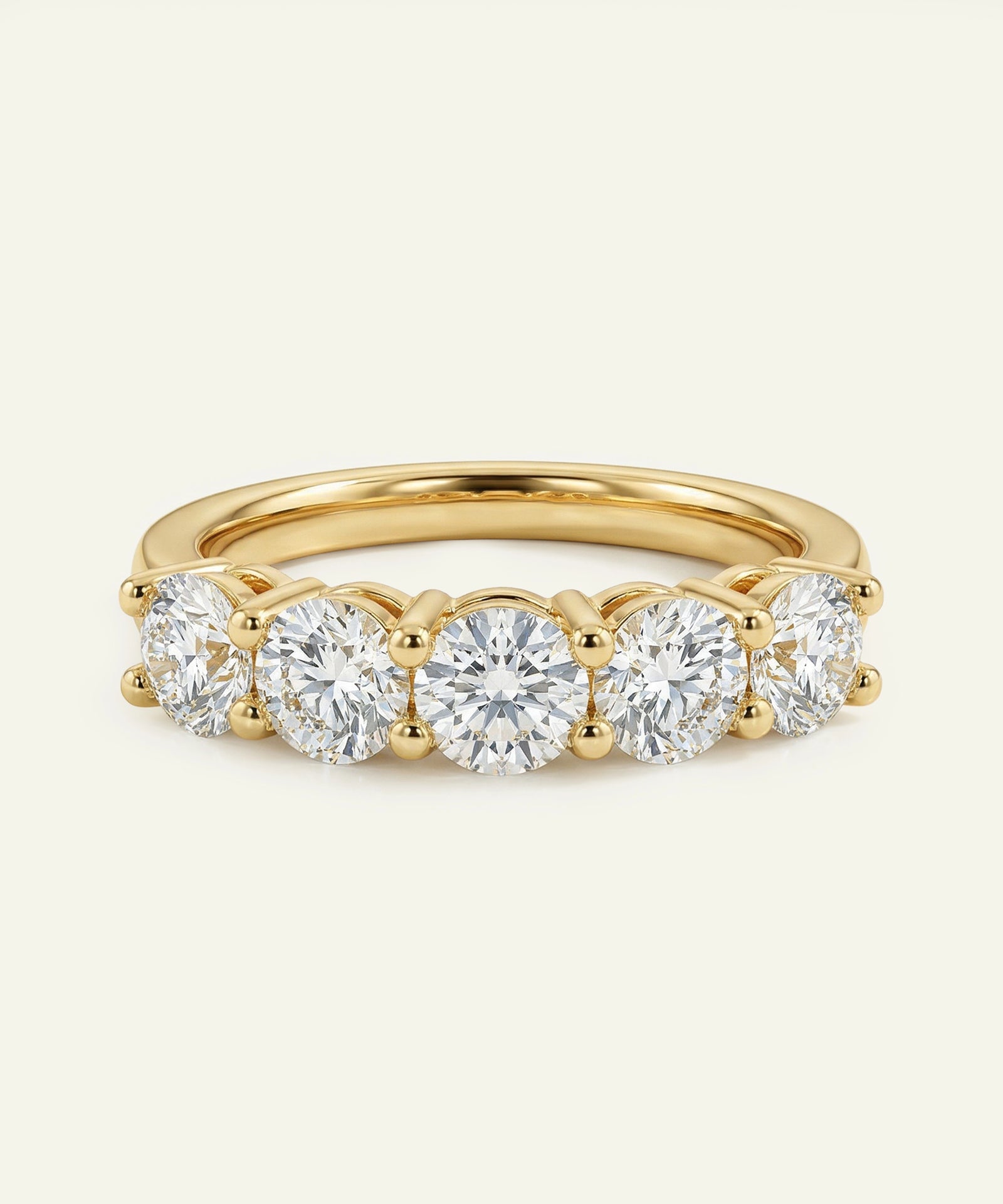 Gold ring with five diamonds on a white background