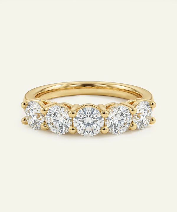 Gold ring with five diamonds on a white background