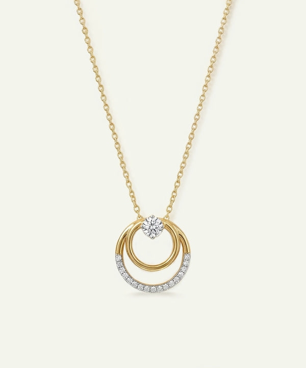 Gold necklace with a circular pendant on a white background