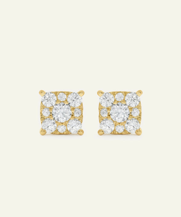Pair of gold square-shaped earrings with clear gemstones on a light beige background
