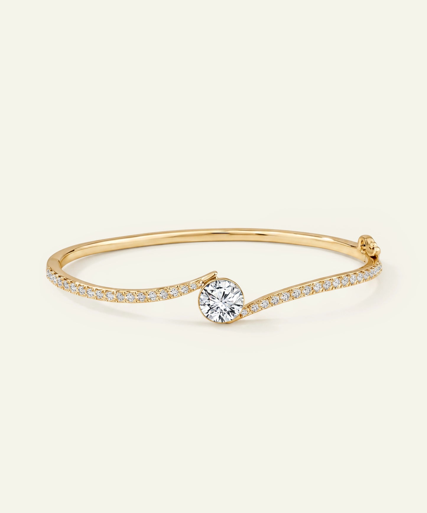 Gold bracelet with a diamond on a light beige background