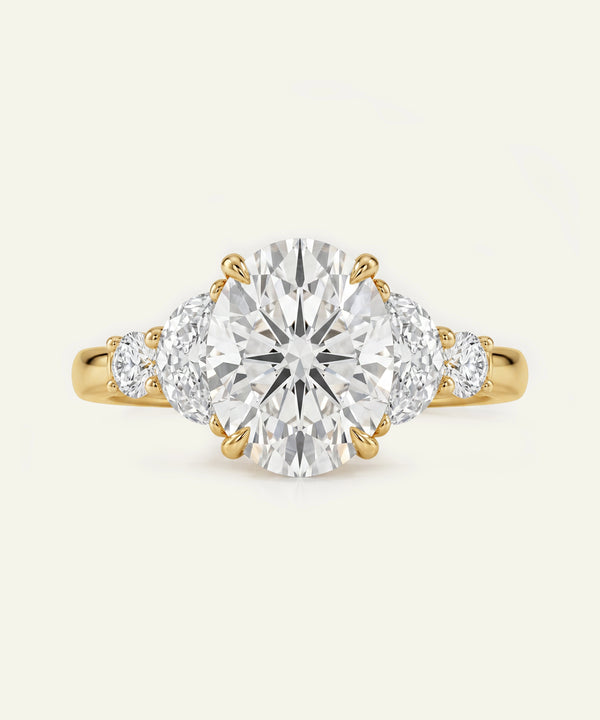 Gold ring with a large diamond and two smaller diamonds on a white background
