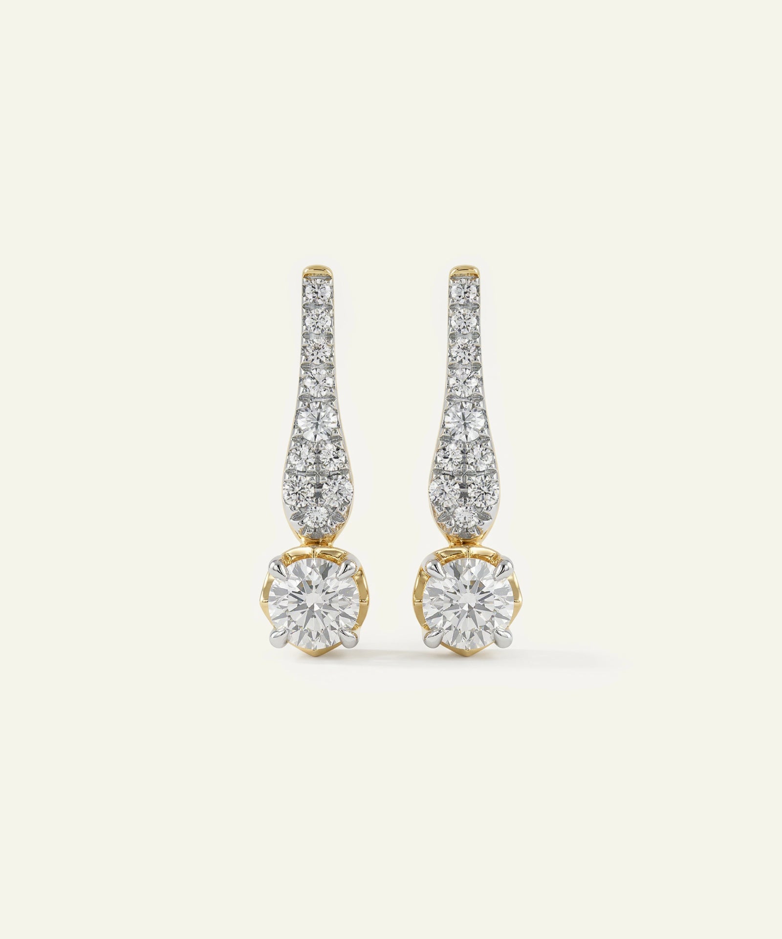 Pair of diamond earrings on a light beige background