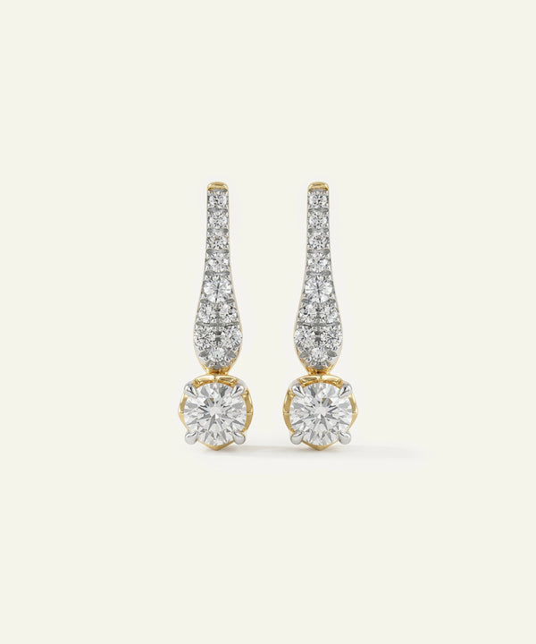 Pair of diamond earrings on a light beige background