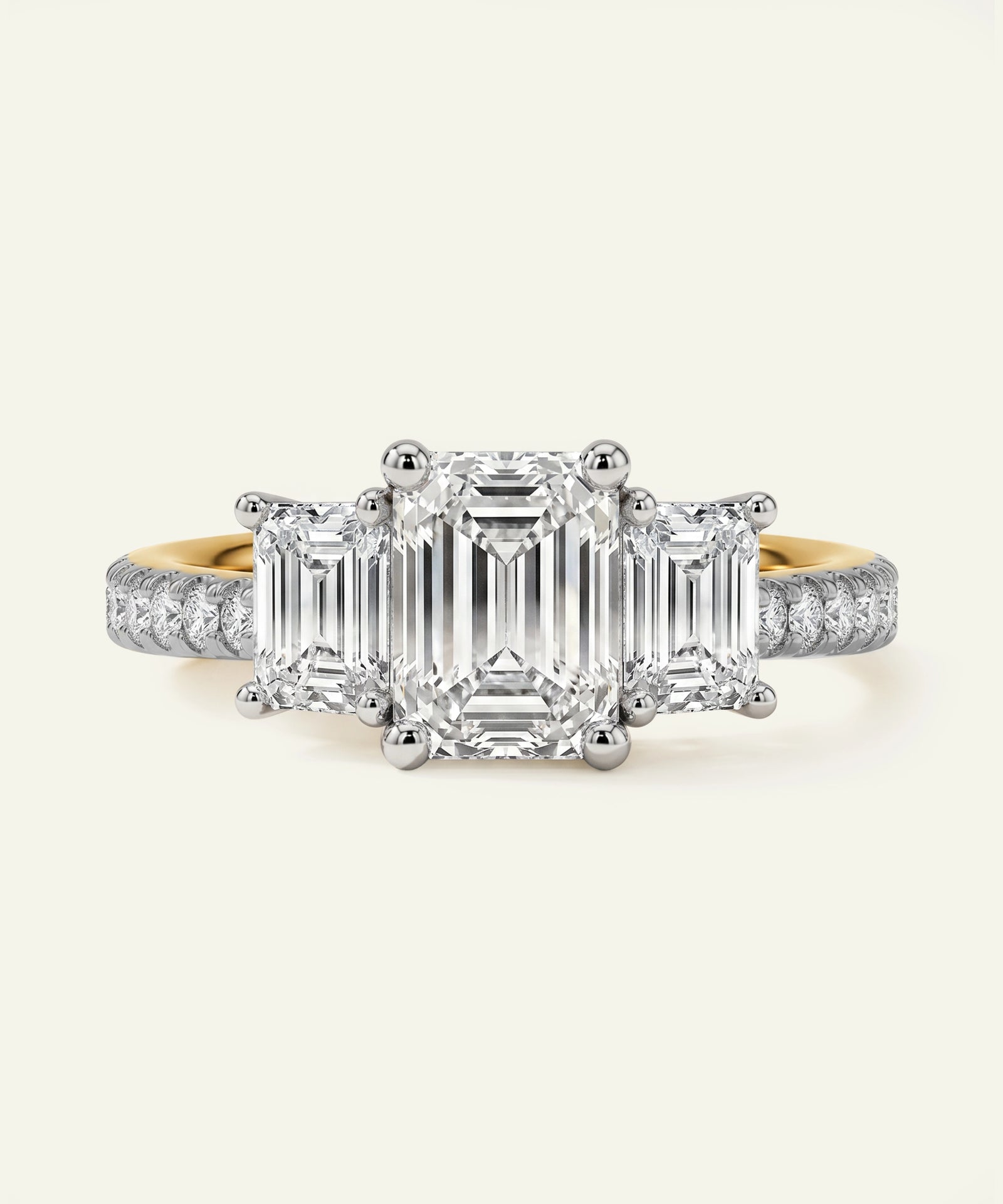 Diamond ring with emerald-cut center stone and smaller diamonds on a white background