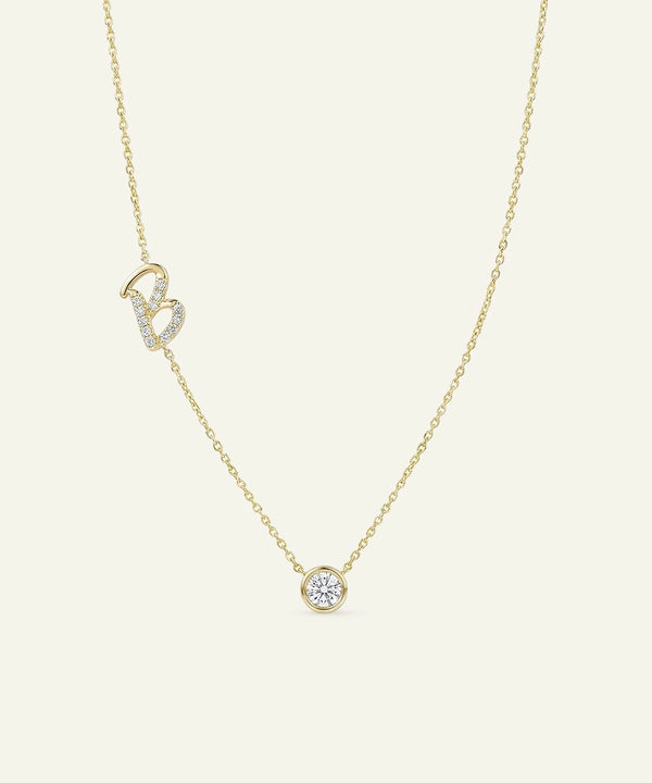 Gold necklace with a small round pendant on a light beige background