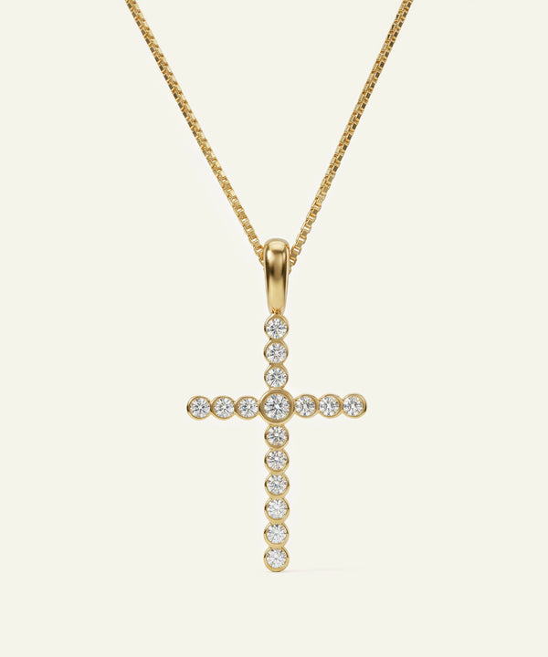 Gold cross pendant necklace with clear stones on a white background