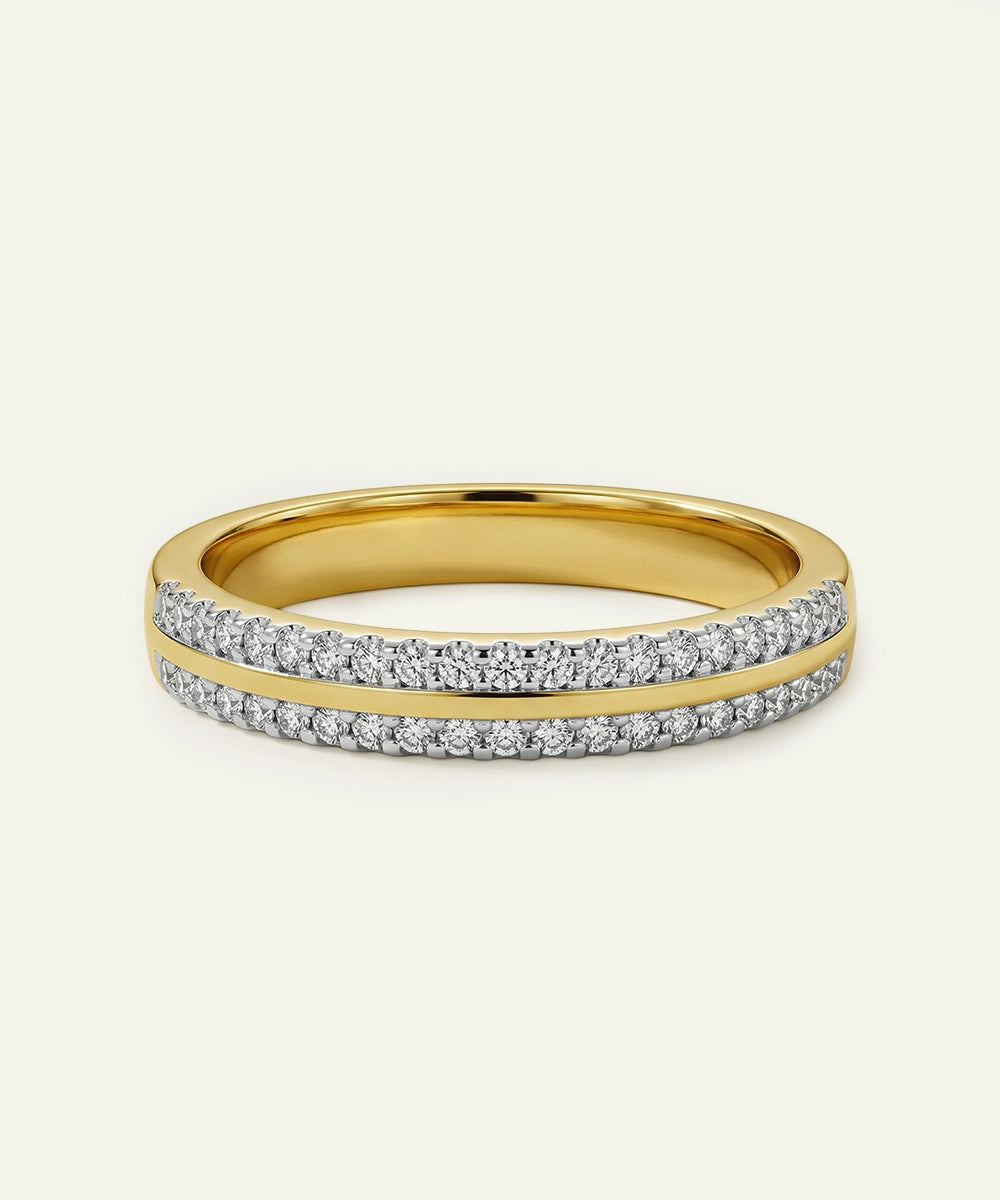 Gold ring with diamond accents on a light beige background
