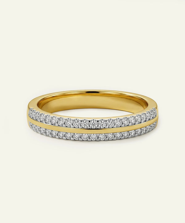 Gold ring with diamond accents on a light beige background