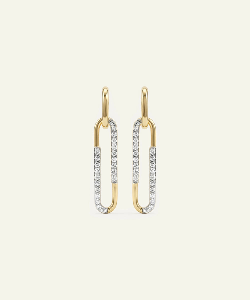 Gold and silver earrings on a light beige background