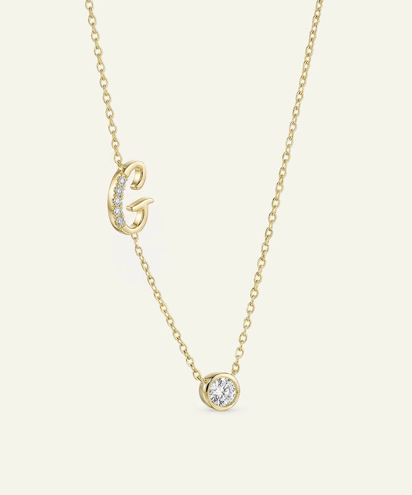 Gold necklace with a small round pendant on a light beige background