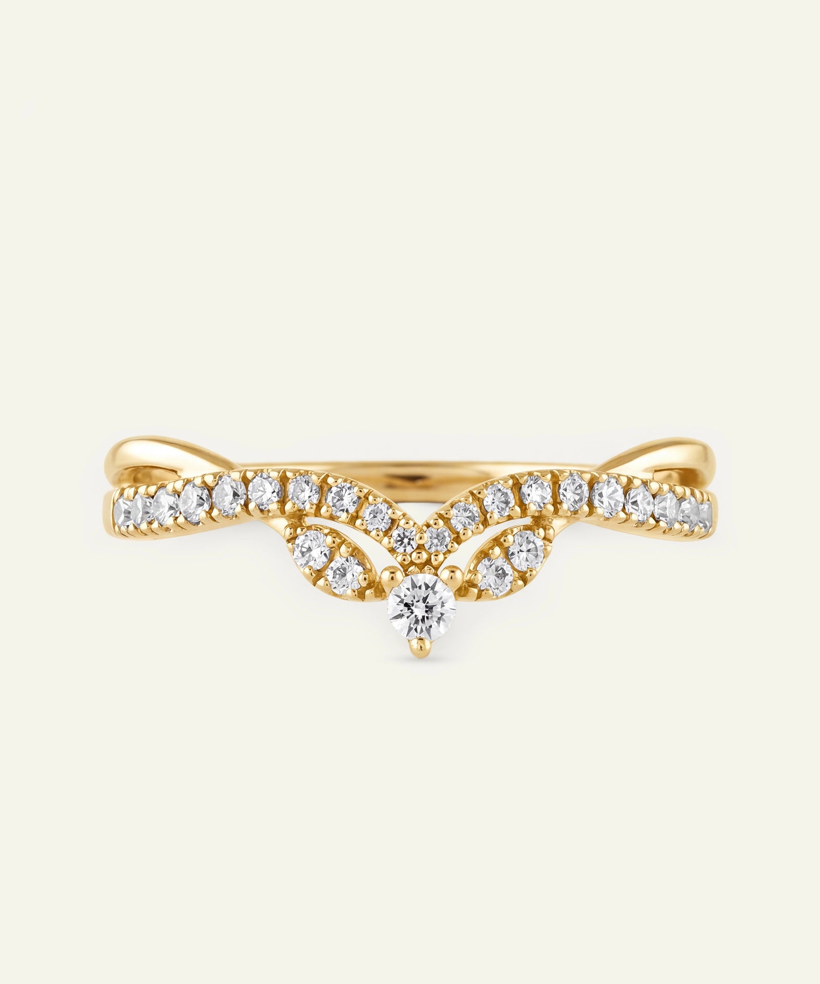 Gold ring with diamonds on a light beige background