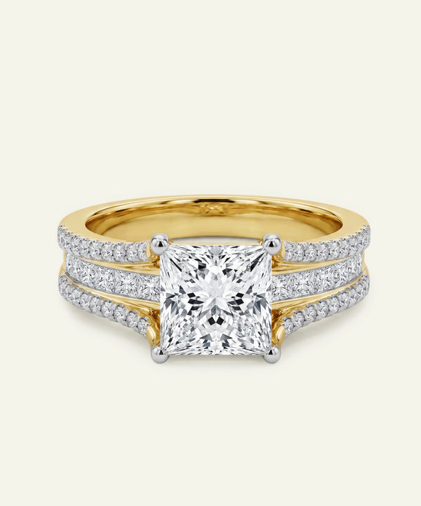 Gold ring with a large diamond and smaller diamonds on the band against a white background