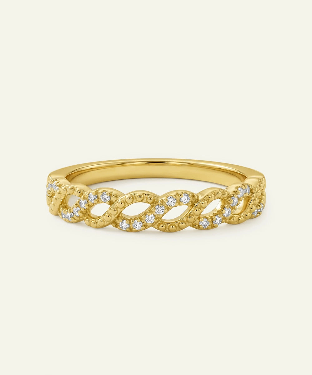 Gold ring with diamond accents on a light beige background
