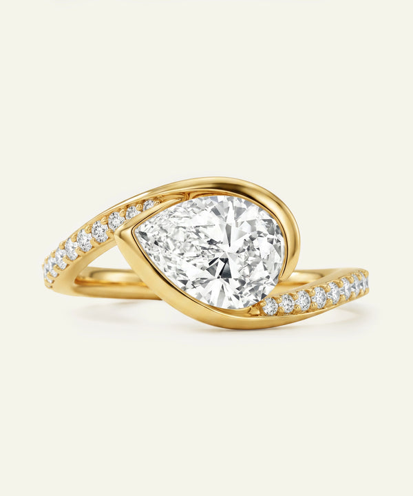 Gold ring with a large diamond and smaller diamonds on the band against a white background