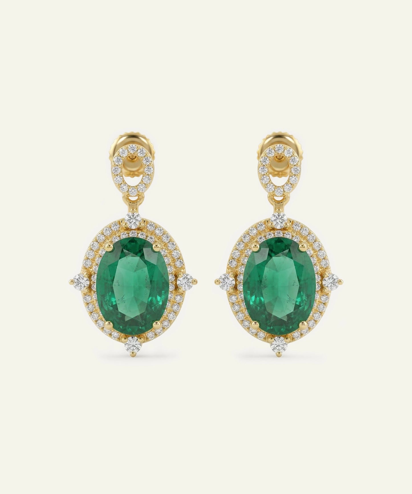 Gold earrings with green gemstones on a white background