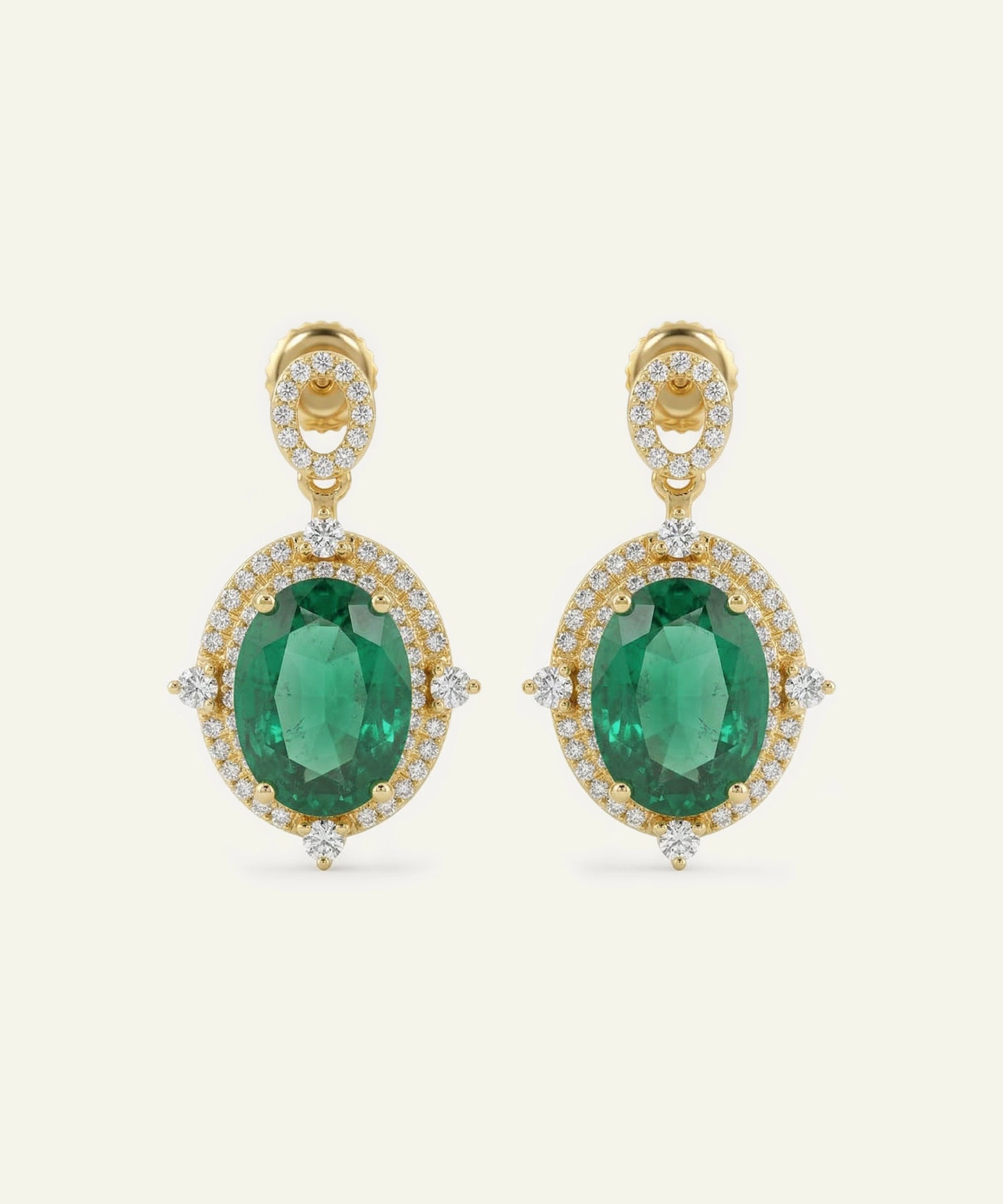 Gold earrings with green gemstones on a white background