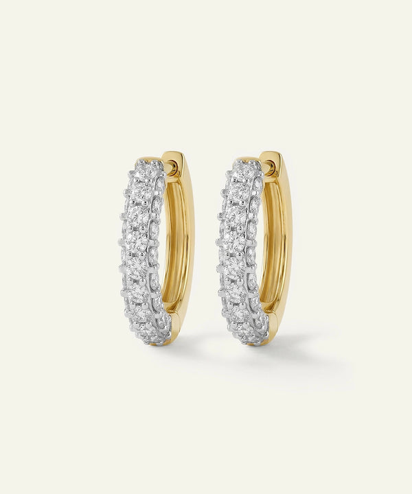 Gold hoop earrings with diamond accents on a light gray background