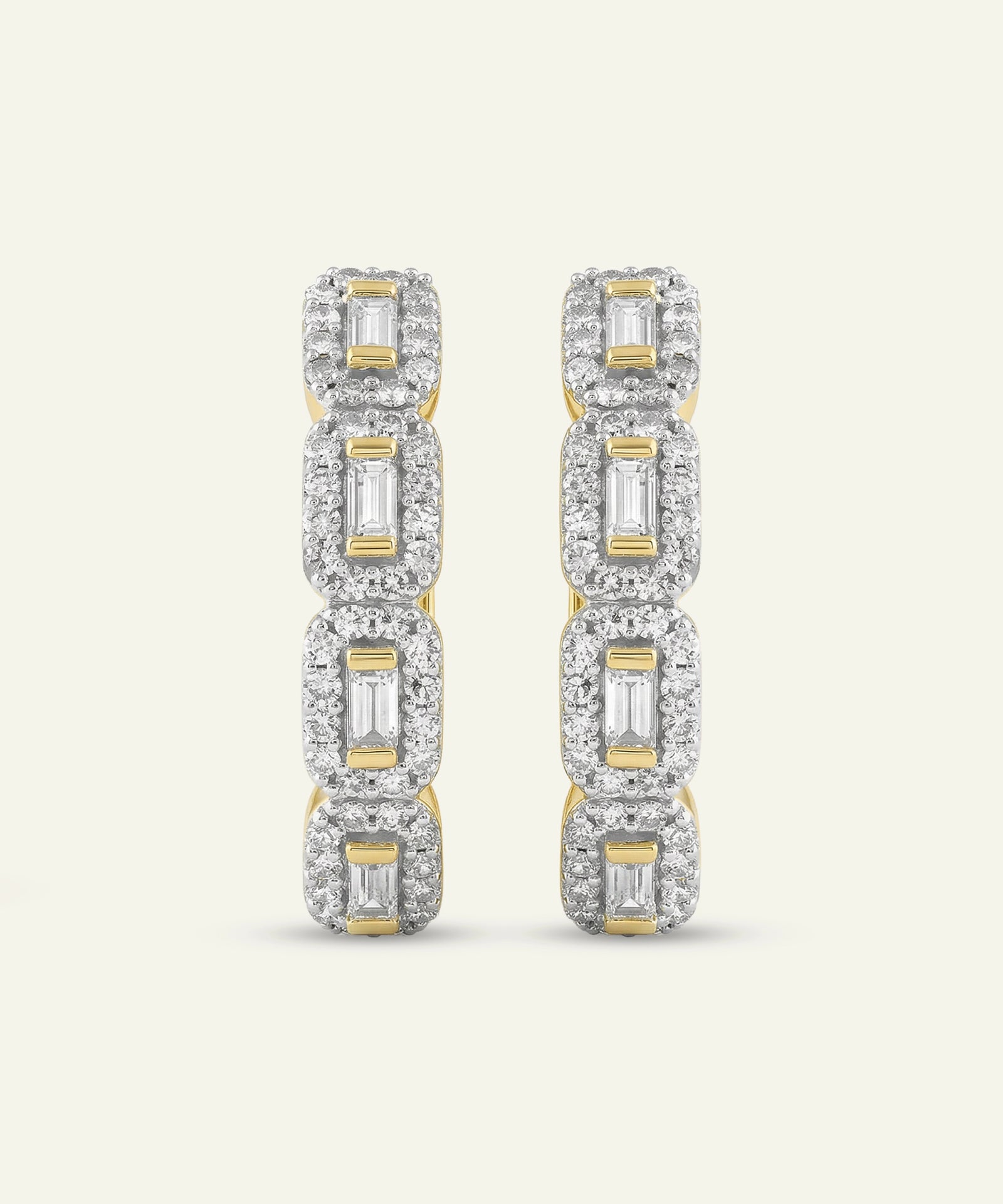 Pair of diamond earrings with gold accents on a light gray background