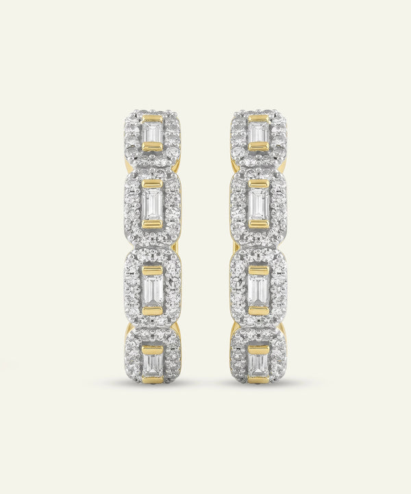 Pair of diamond earrings with gold accents on a light gray background