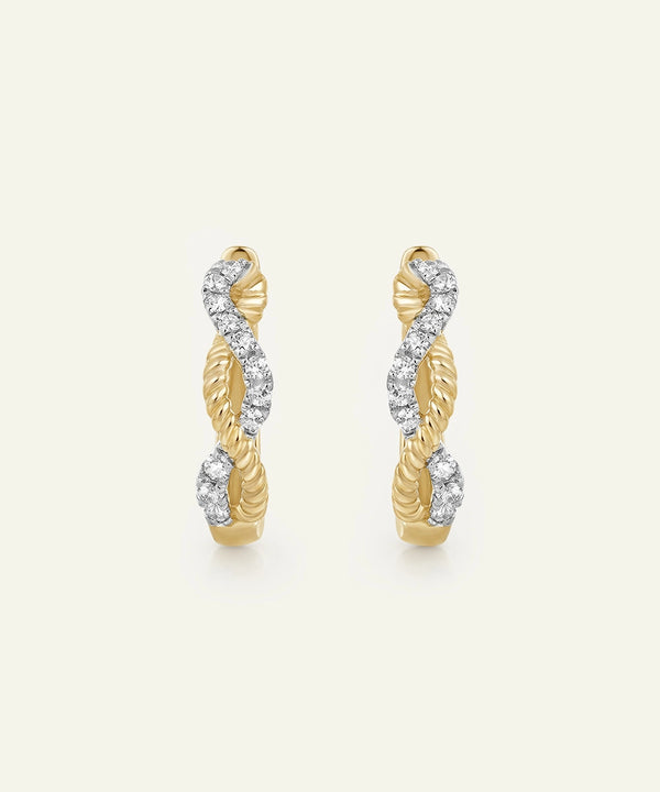 Pair of gold hoop earrings with diamond accents on a light beige background