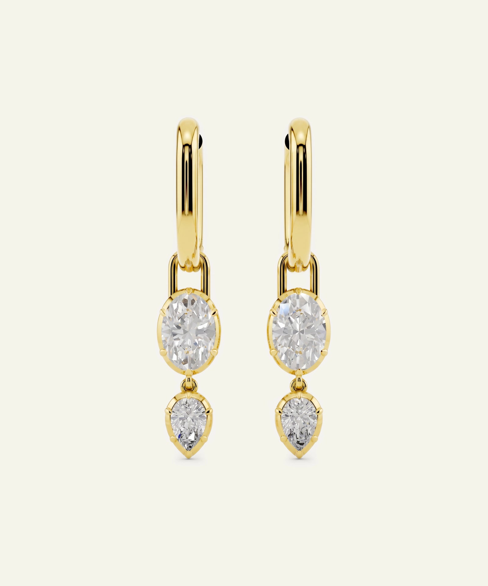 Gold earrings with three clear gemstones on a white background