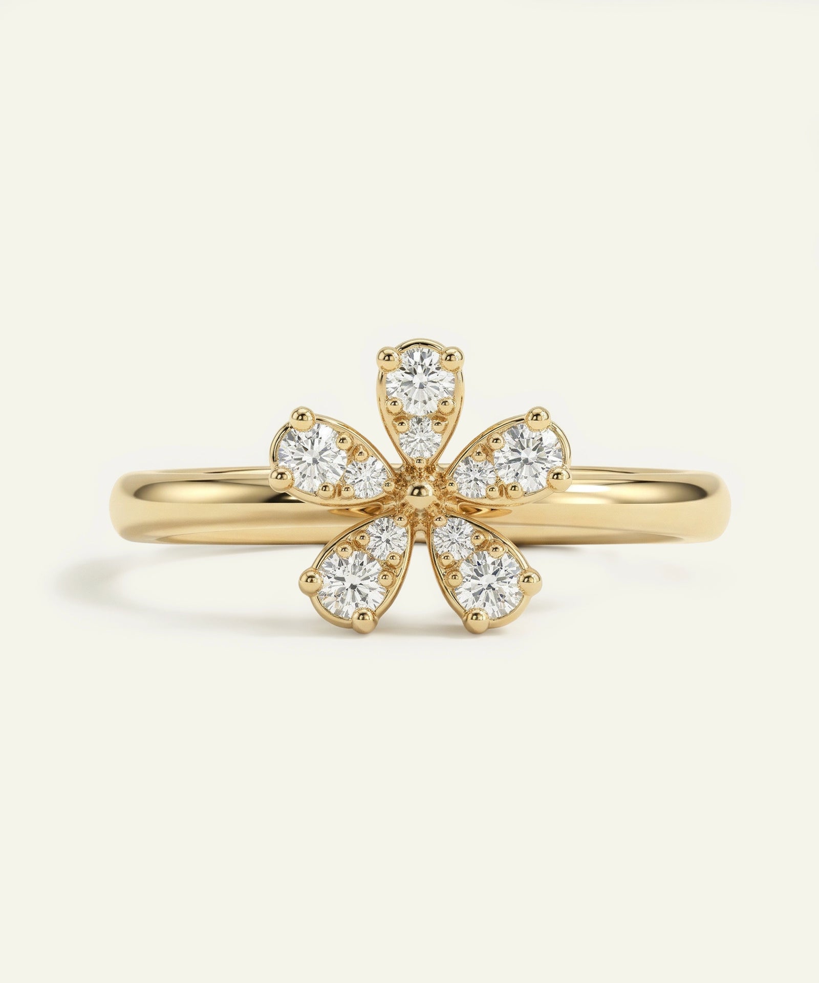 Gold ring with diamond petals on a light beige background