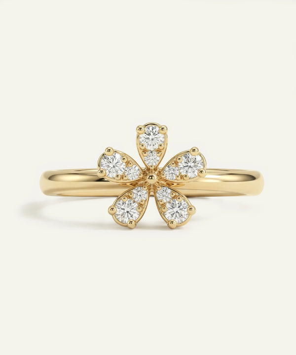 Gold ring with diamond petals on a light beige background