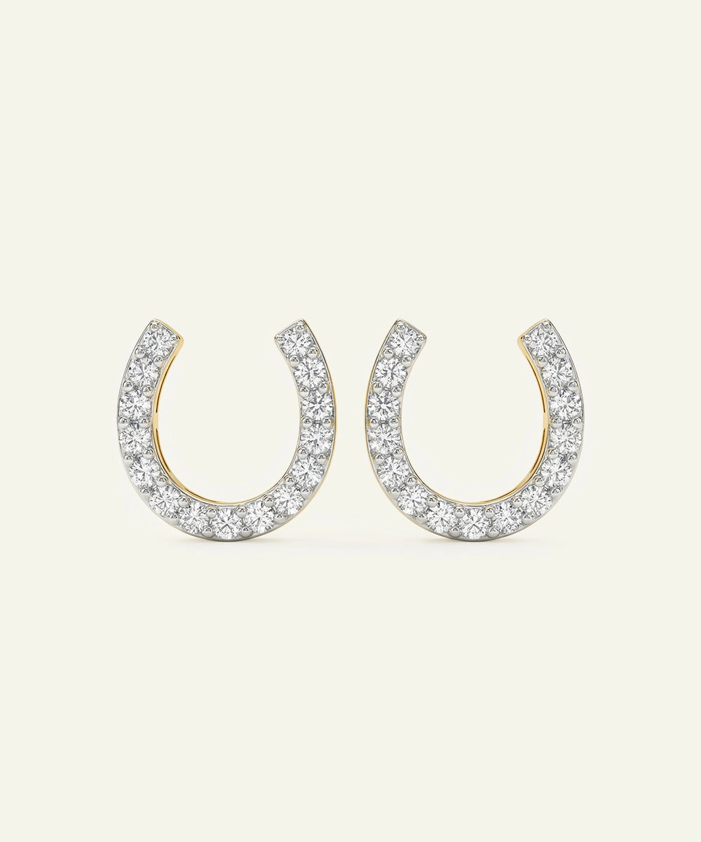 Horseshoe-shaped earrings with diamond accents on a white background