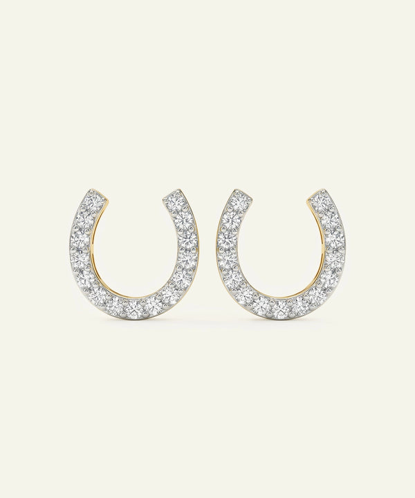 Horseshoe-shaped earrings with diamond accents on a white background