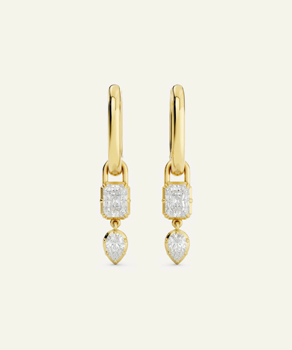 Gold earrings with diamond-like stones on a white background