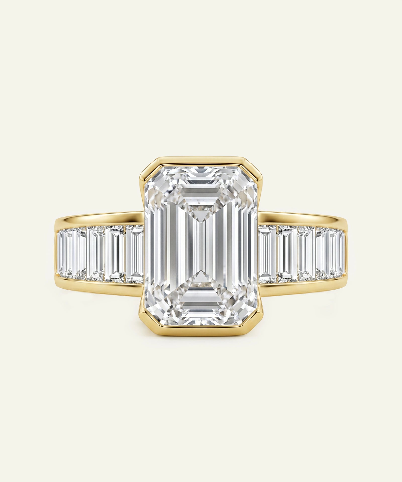 Diamond ring with emerald-cut center stone and baguette side stones on a white background