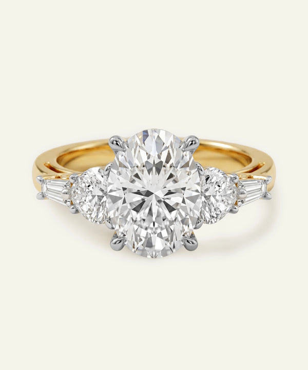 Gold ring with a large diamond and smaller diamonds on the sides against a white background