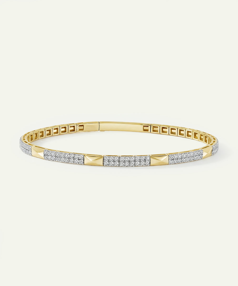 Gold bracelet with diamond accents on a light beige background