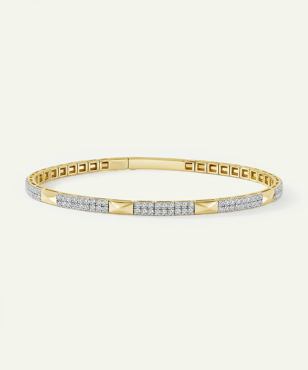Gold bracelet with diamond accents on a light beige background
