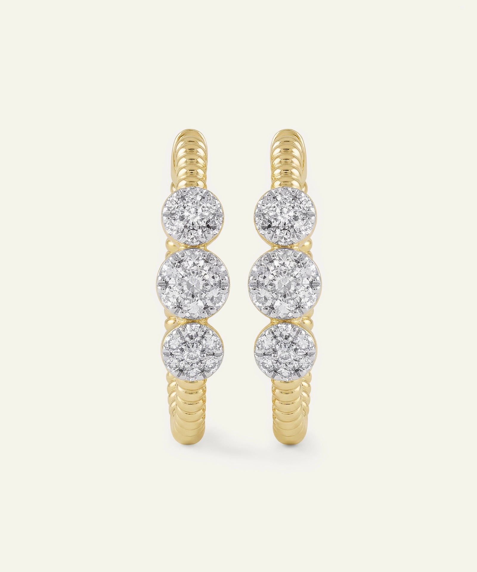 Gold hoop earrings with diamond beads on a white background