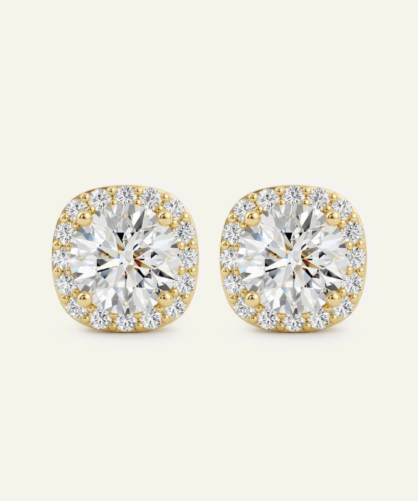Gold and diamond earrings on a beige background