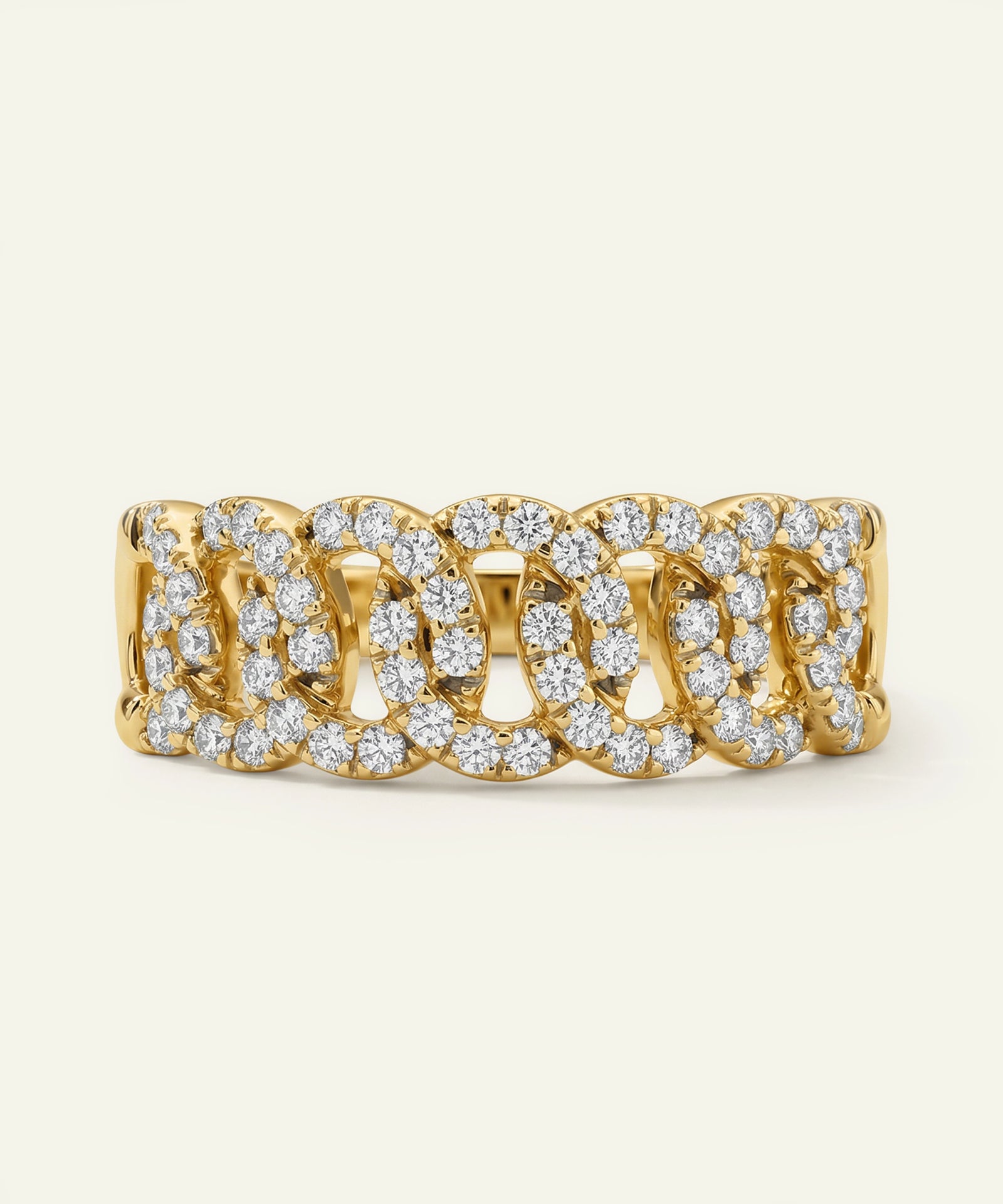 Gold ring with diamond accents on a light beige background