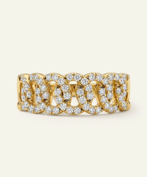 Gold ring with diamond accents on a light beige background