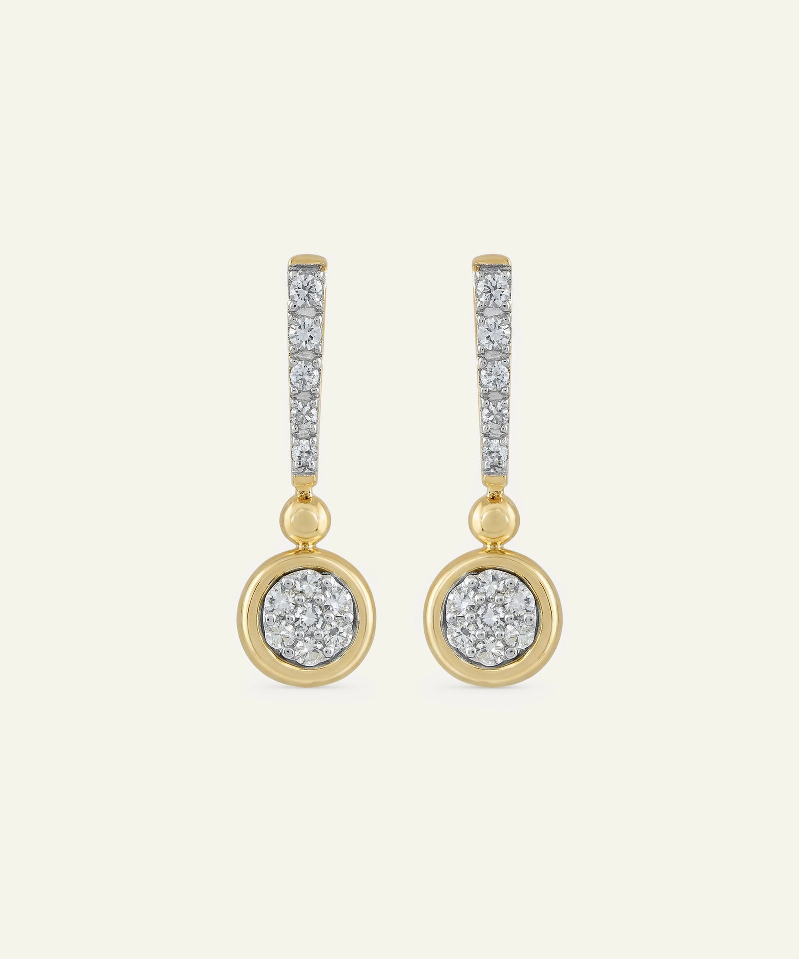 Gold and silver earrings on a light beige background