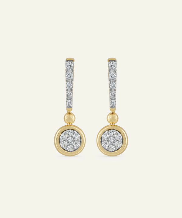 Gold and silver earrings on a light beige background