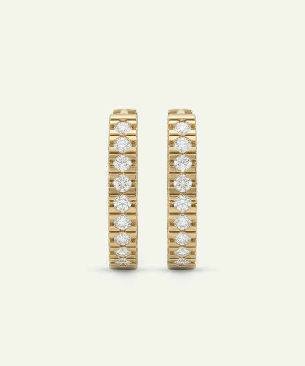 Two gold rings with diamond accents on a beige background