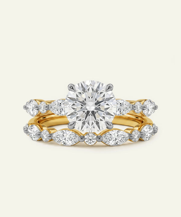 Gold ring with a large diamond and smaller diamonds on a light gray background